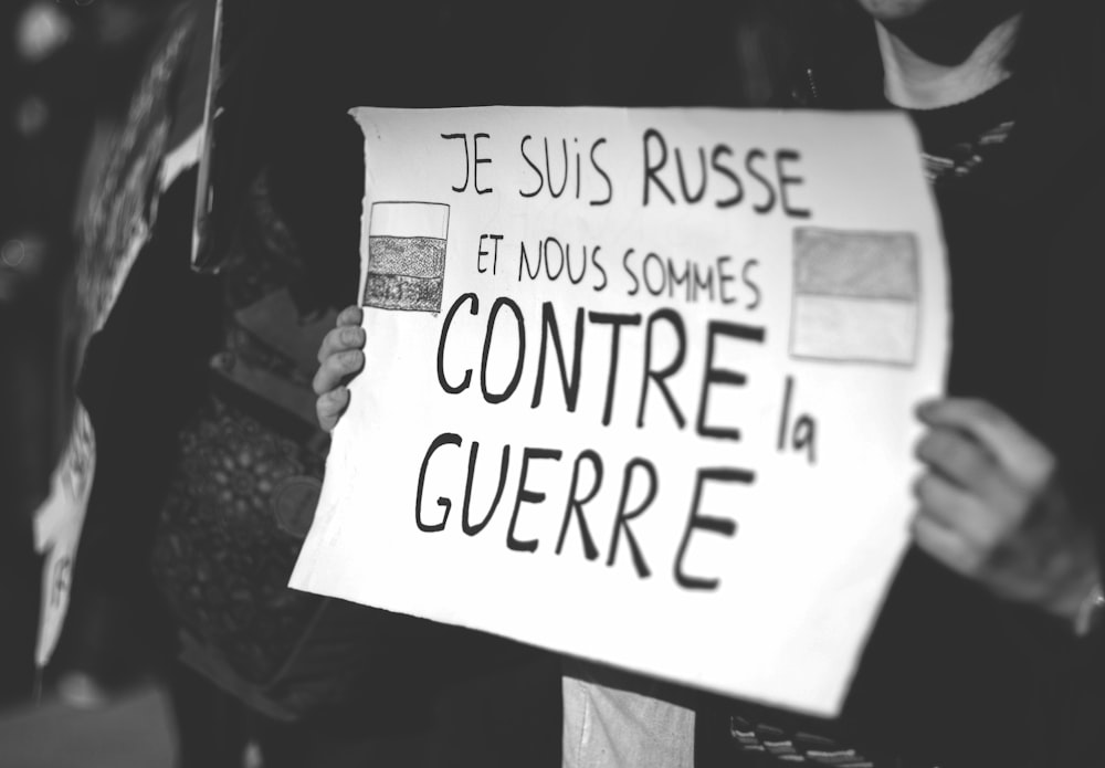a person holding a sign that says je suis risse et mous some