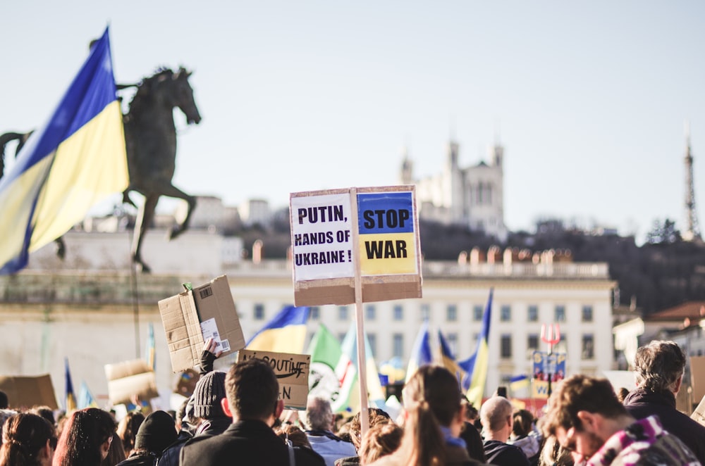 a crowd of people holding signs and flags