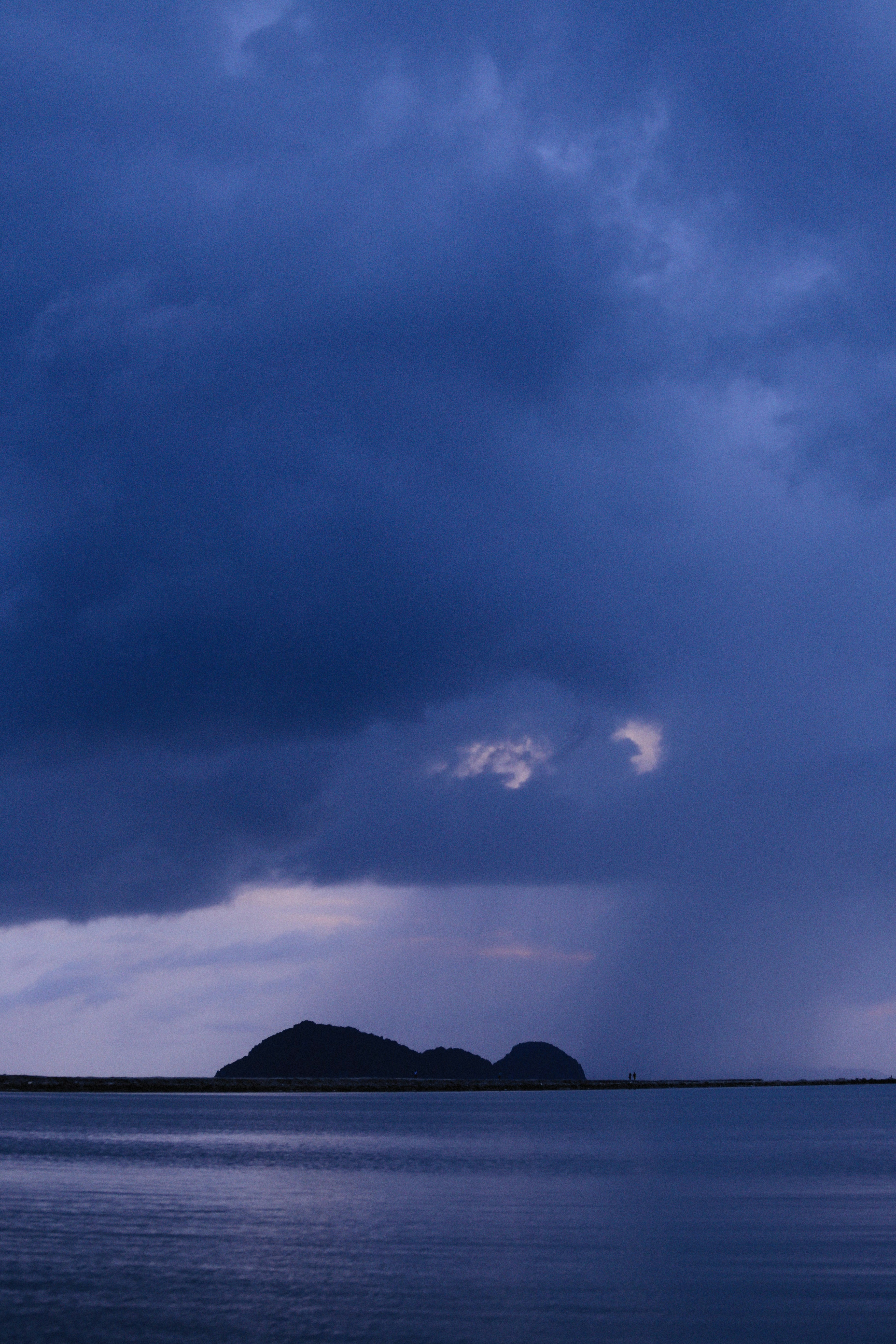 A large body of water under a cloudy sky photo – Free Blue Image on ...