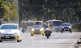 a group of motorcyclists driving down a road