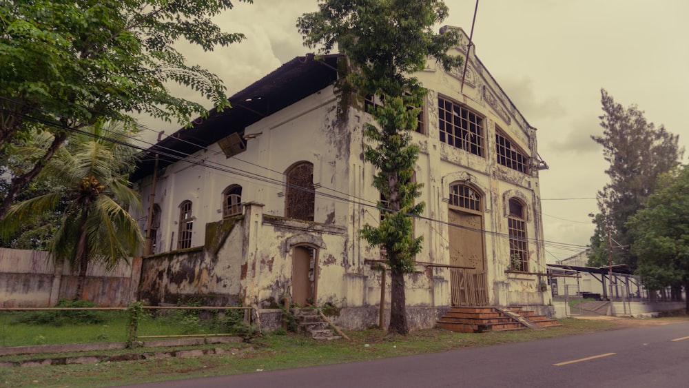 an old run down building sitting on the side of a road