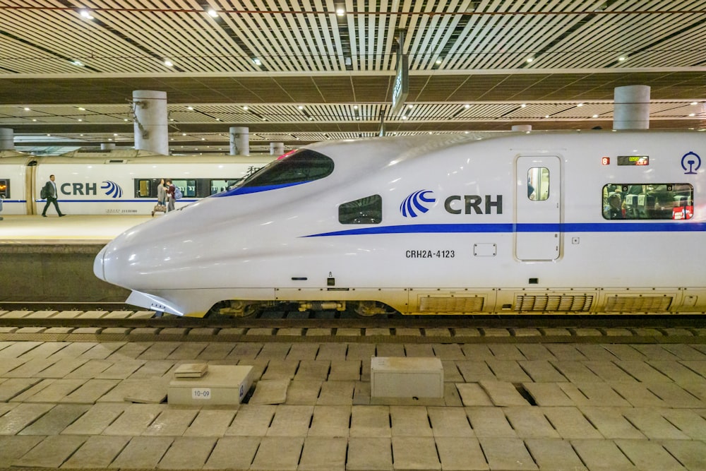 a white and blue train sitting in a train station