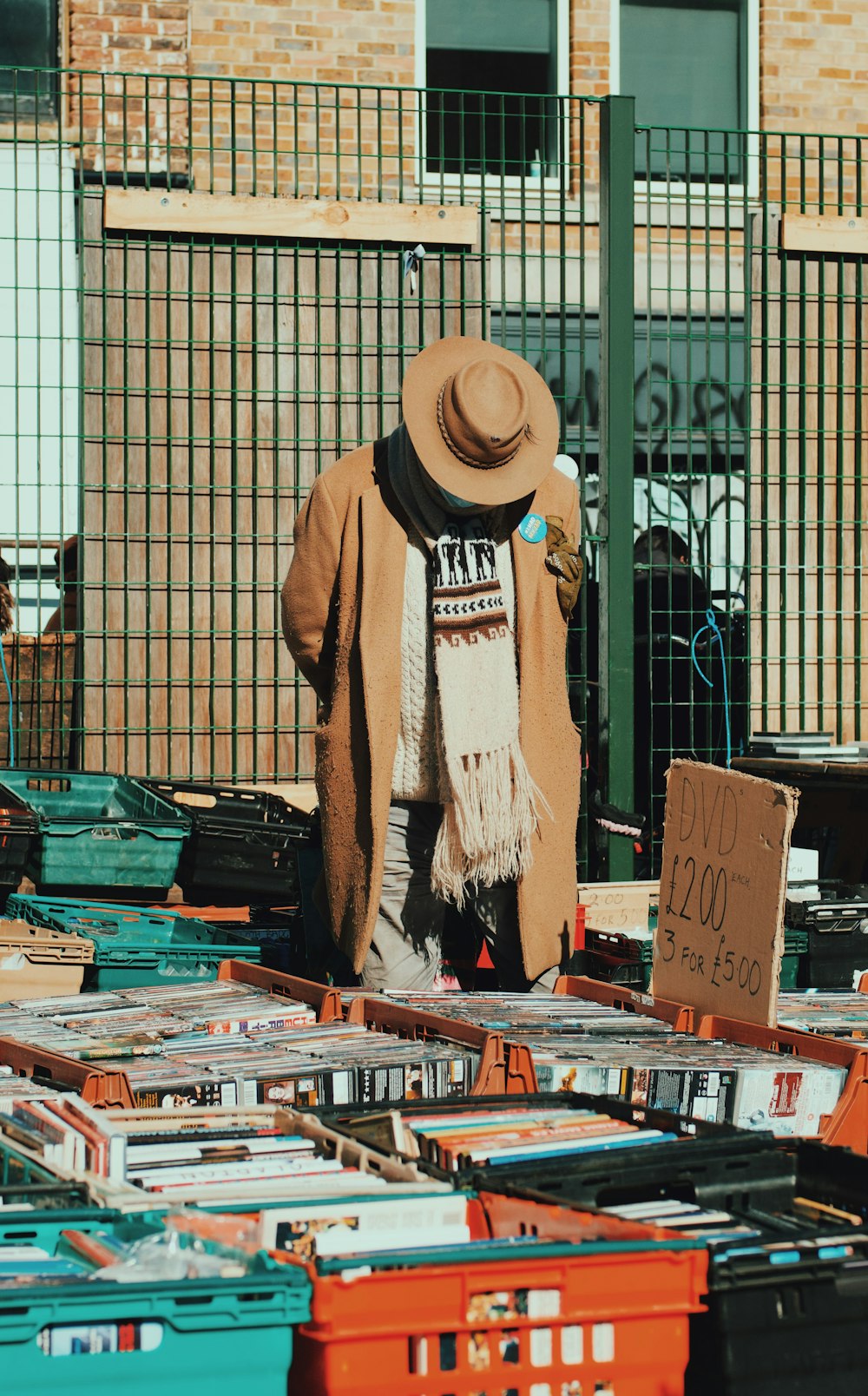 Un homme debout devant une pile de livres