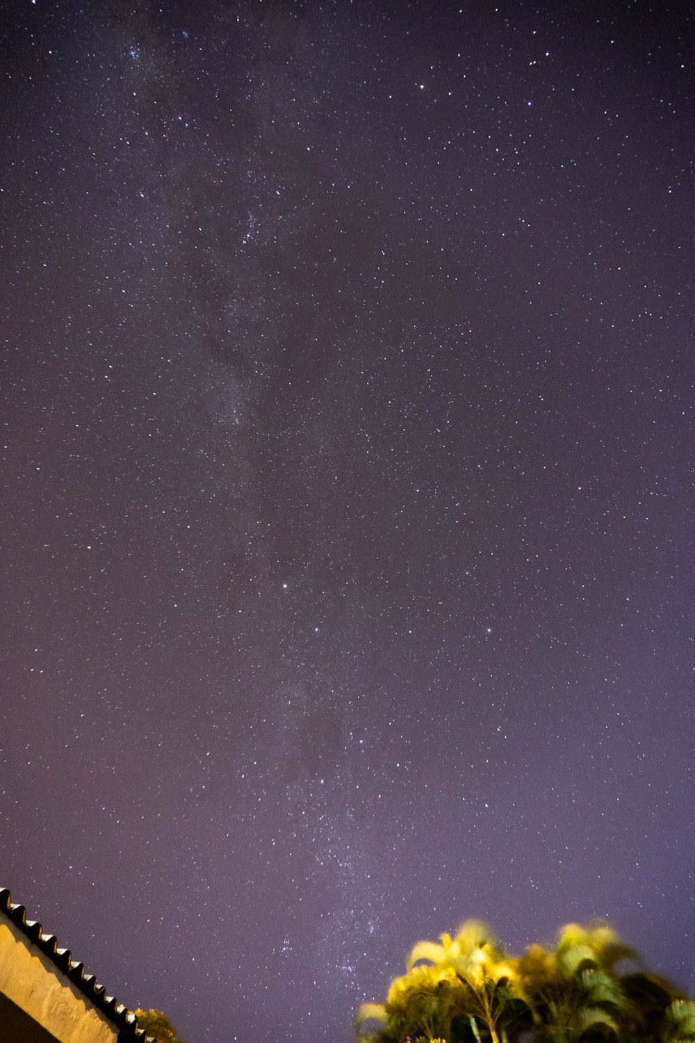 the night sky with stars above a building