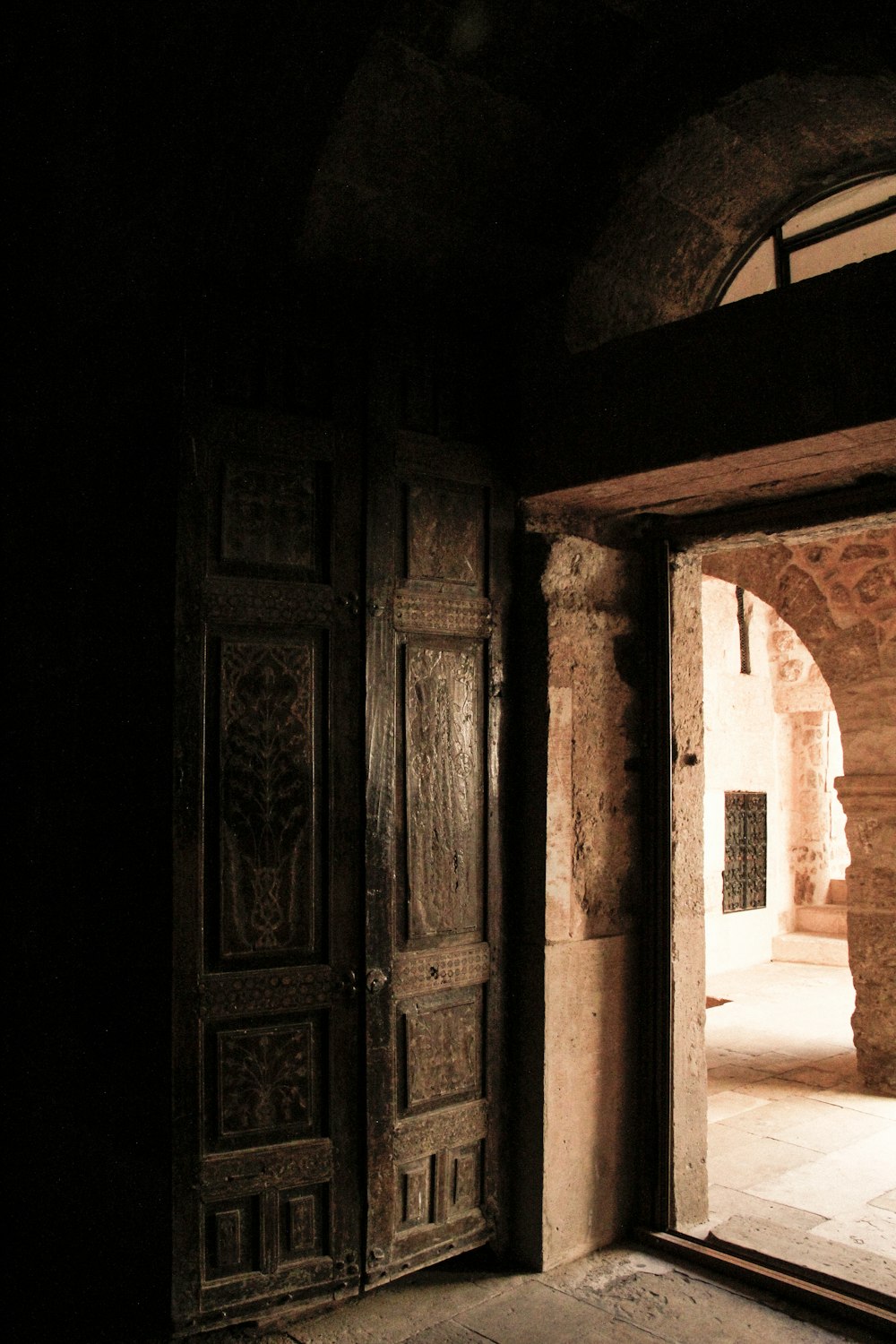 an open door in a dark room with a clock on the wall