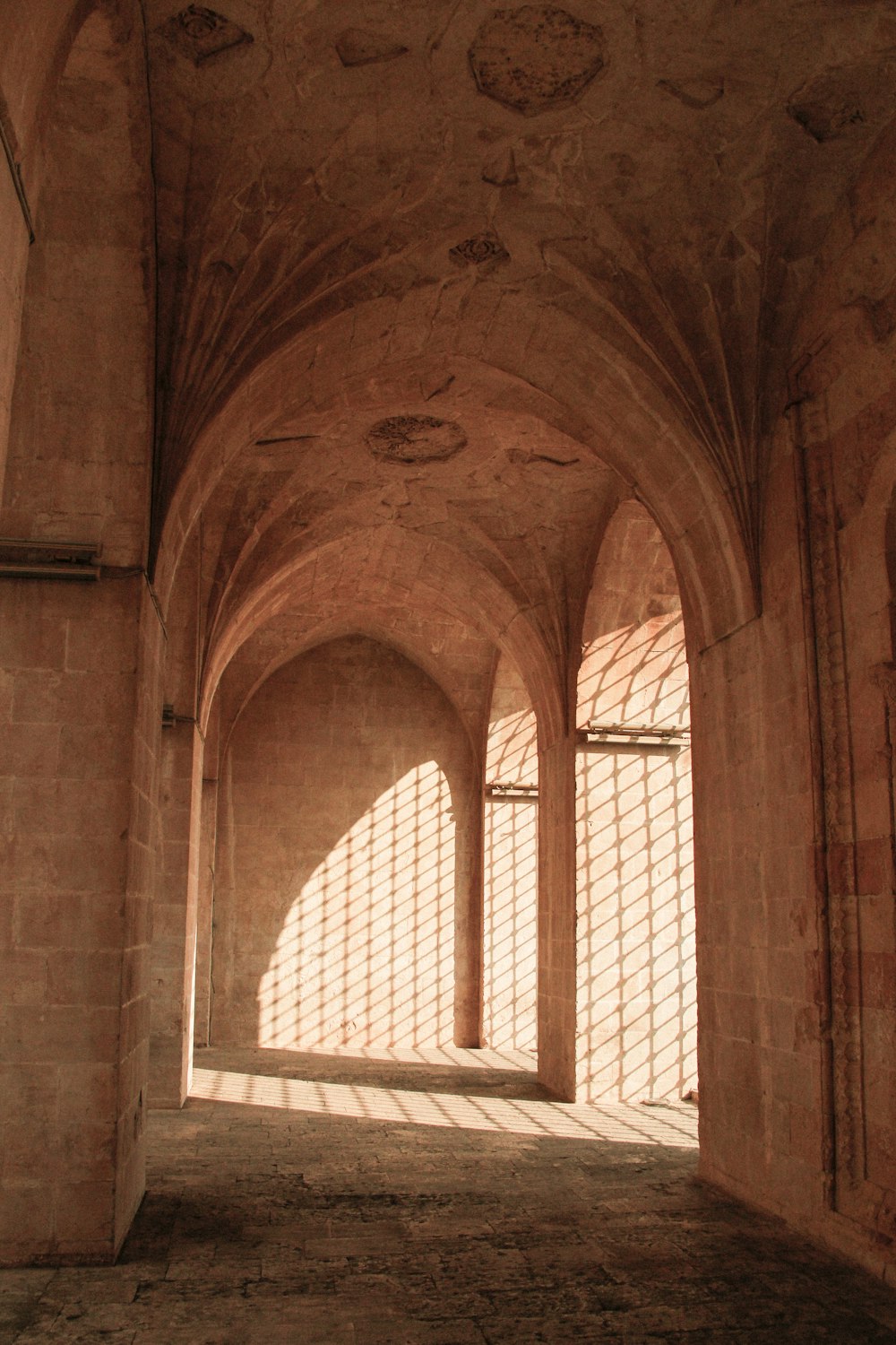 a long hallway with arched walls and a clock on the wall