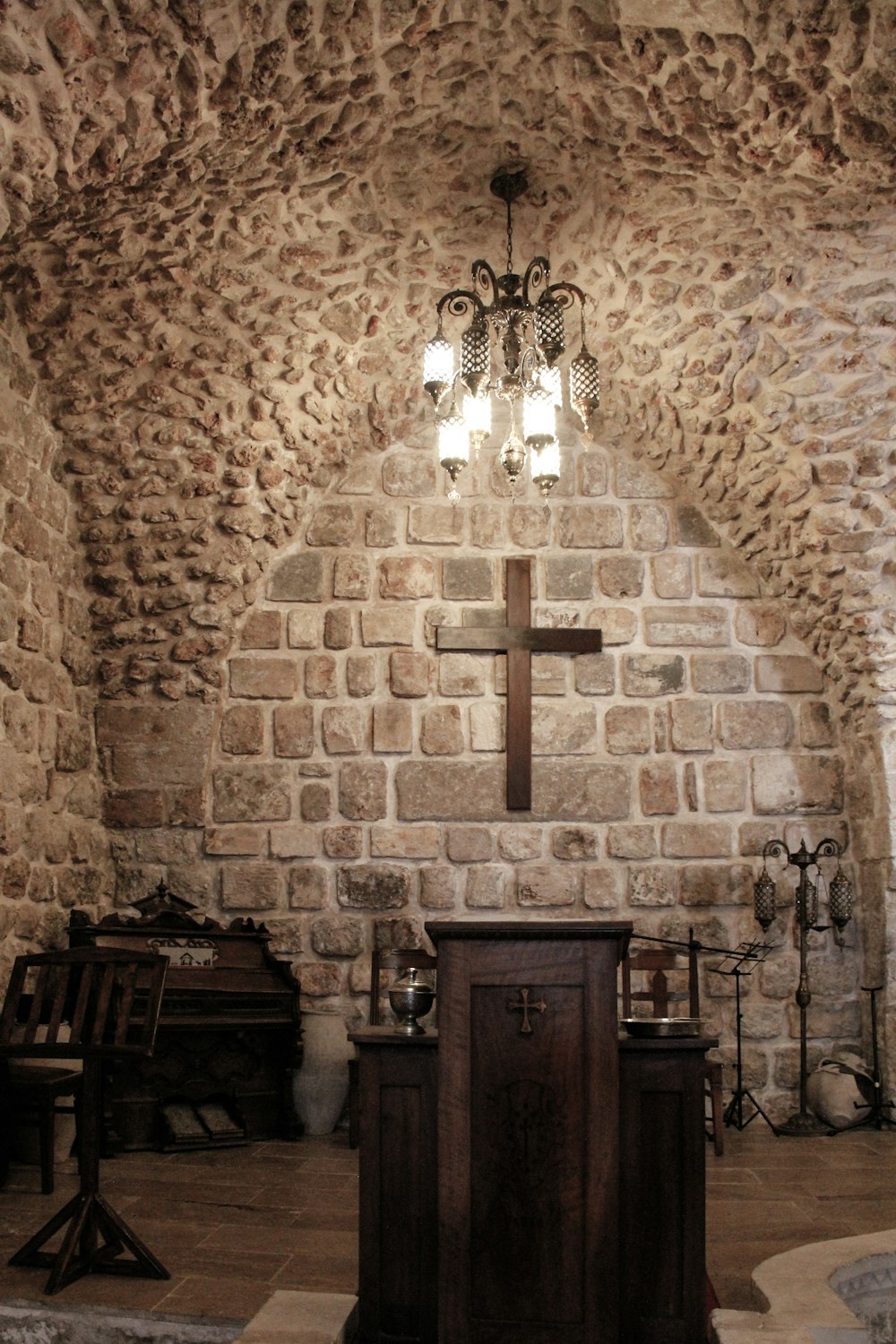 a church with a stone wall and a cross