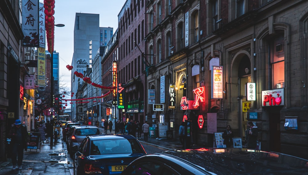 a city street filled with lots of traffic next to tall buildings