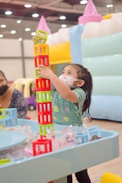 a little girl playing with a building set