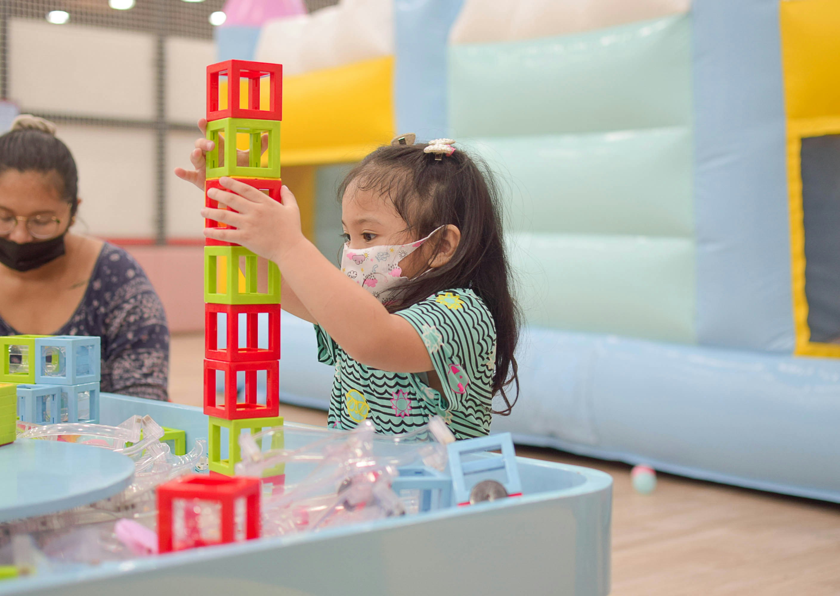 a little girl playing with a building set