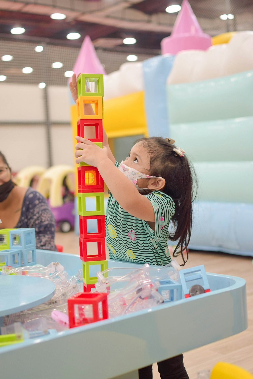 a little girl playing with a toy tower