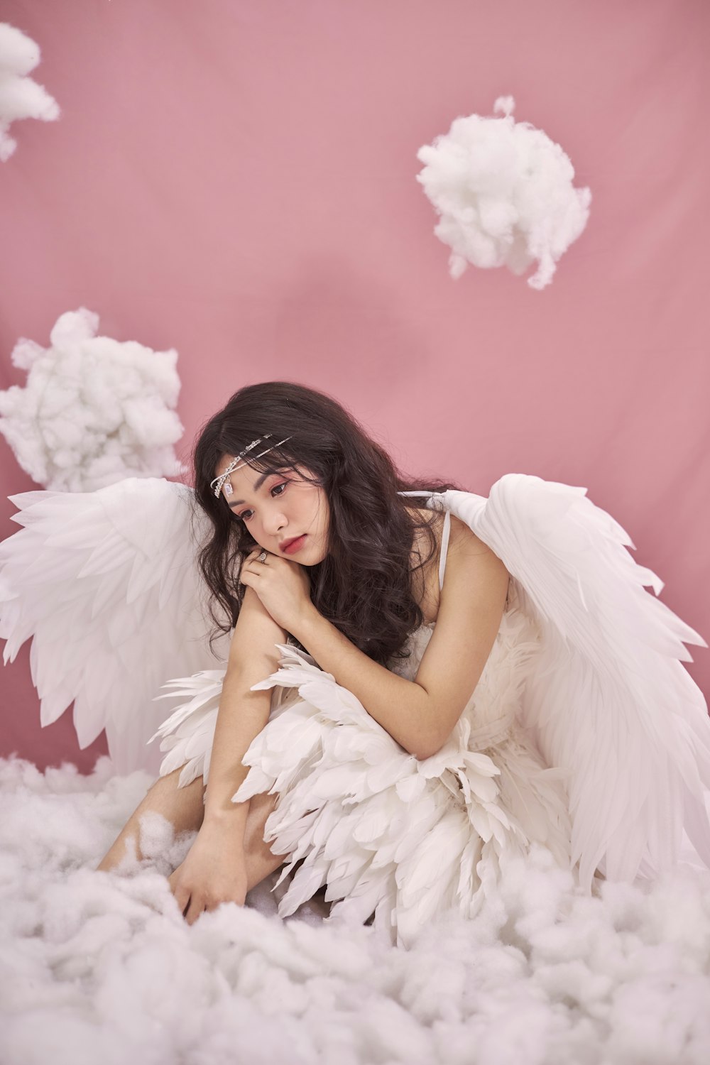 a woman sitting on top of a cloud covered ground