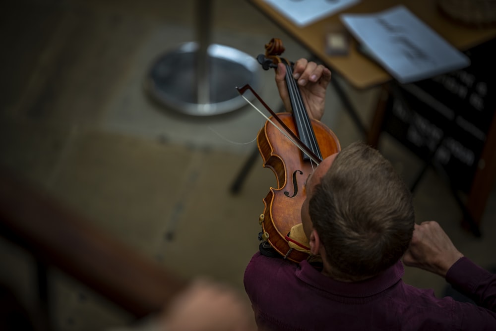 a man playing a violin in a room