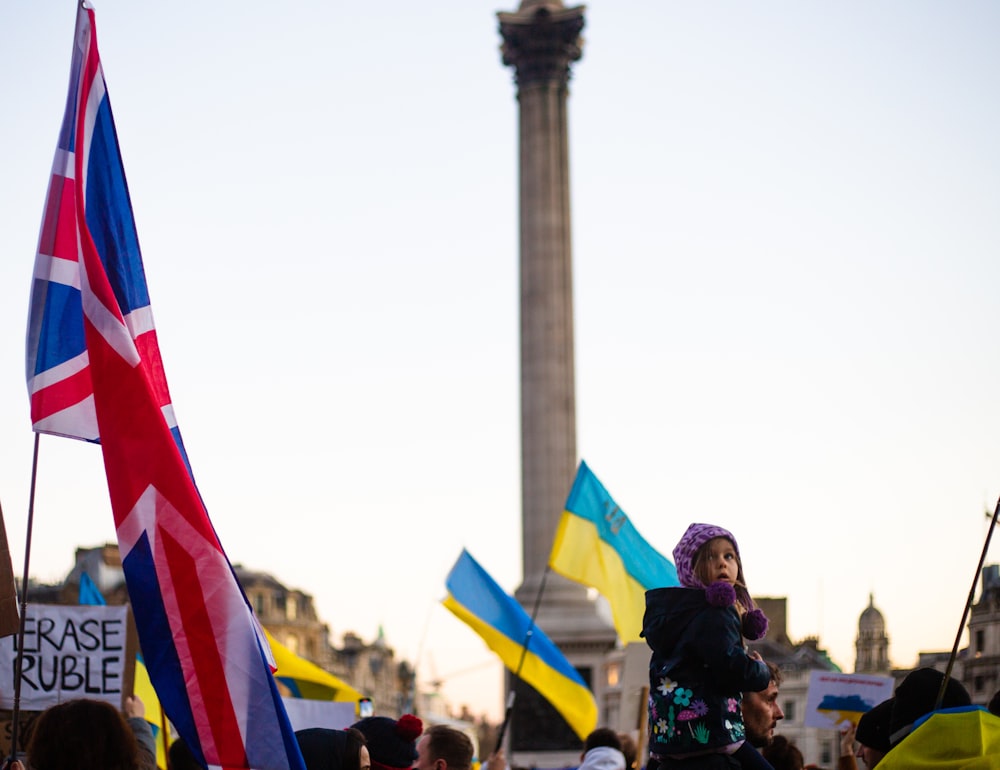 a crowd of people standing around a monument with flags