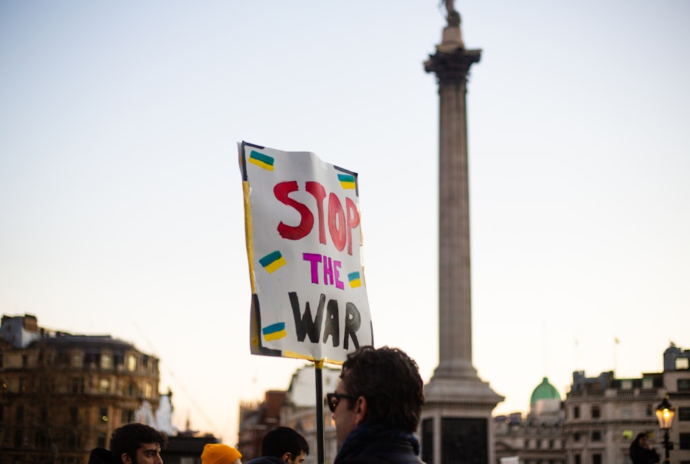 Un uomo con un cartello che dice Stop alla guerra