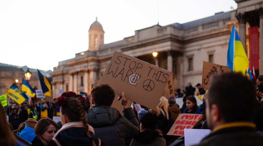 a crowd of people holding signs and flags