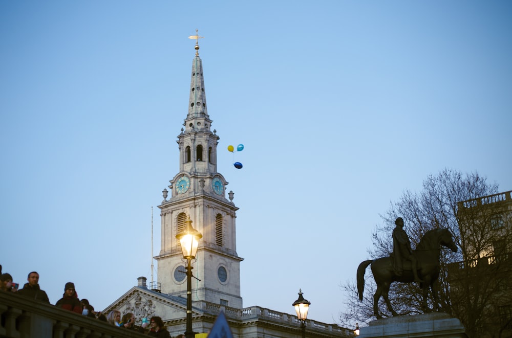 un alto edificio con una torre dell'orologio e una statua di un uomo su un cavallo