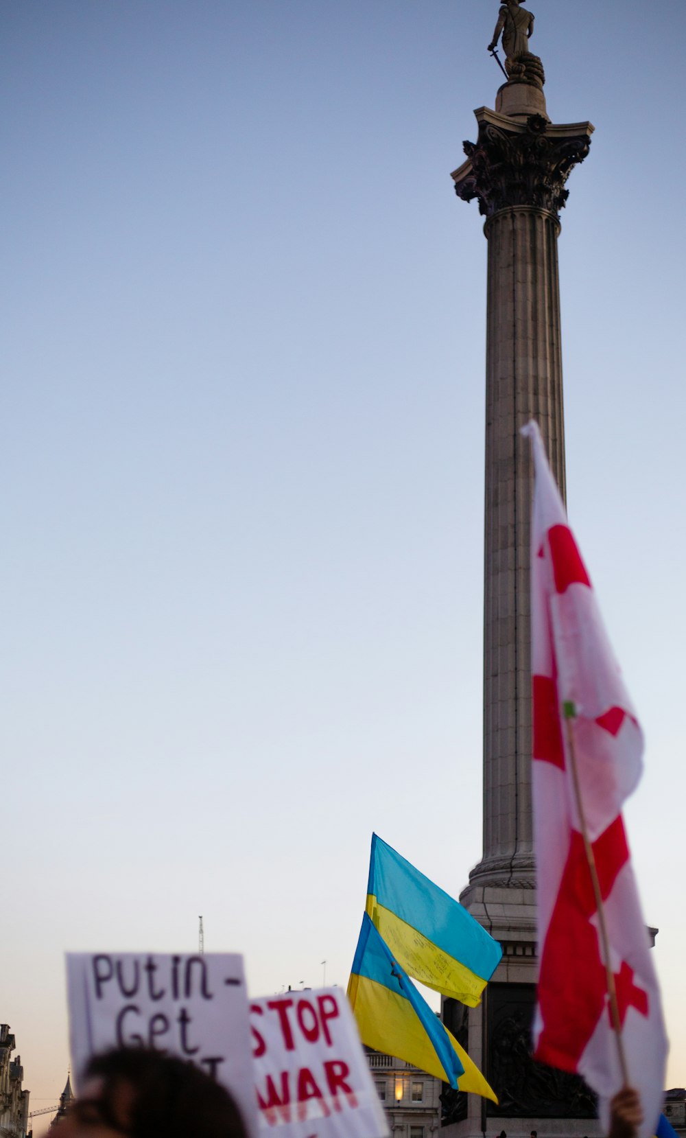 a group of people holding signs in front of a monument