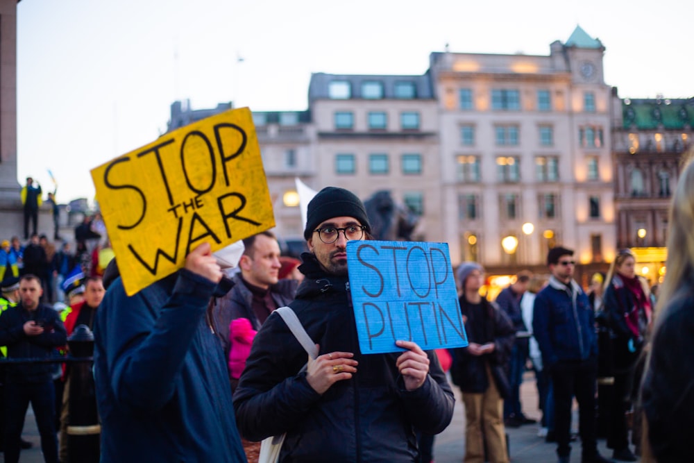 Un uomo con un cartello che dice Stop alla guerra