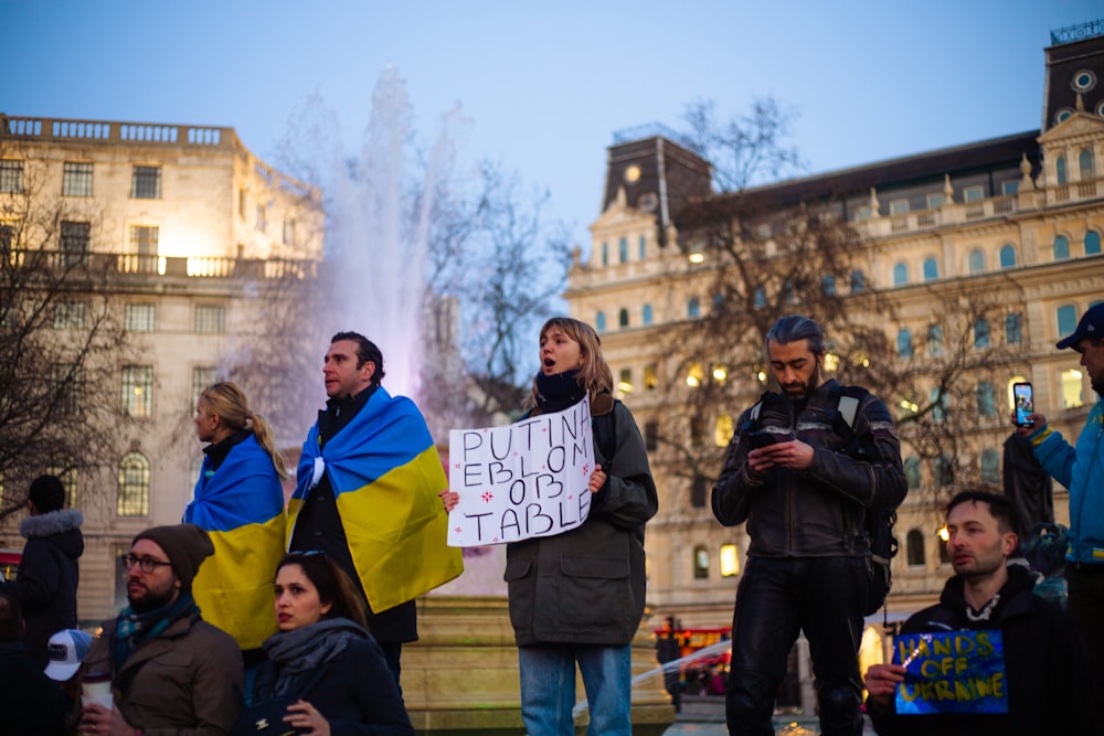 a group of people standing around each other holding signs