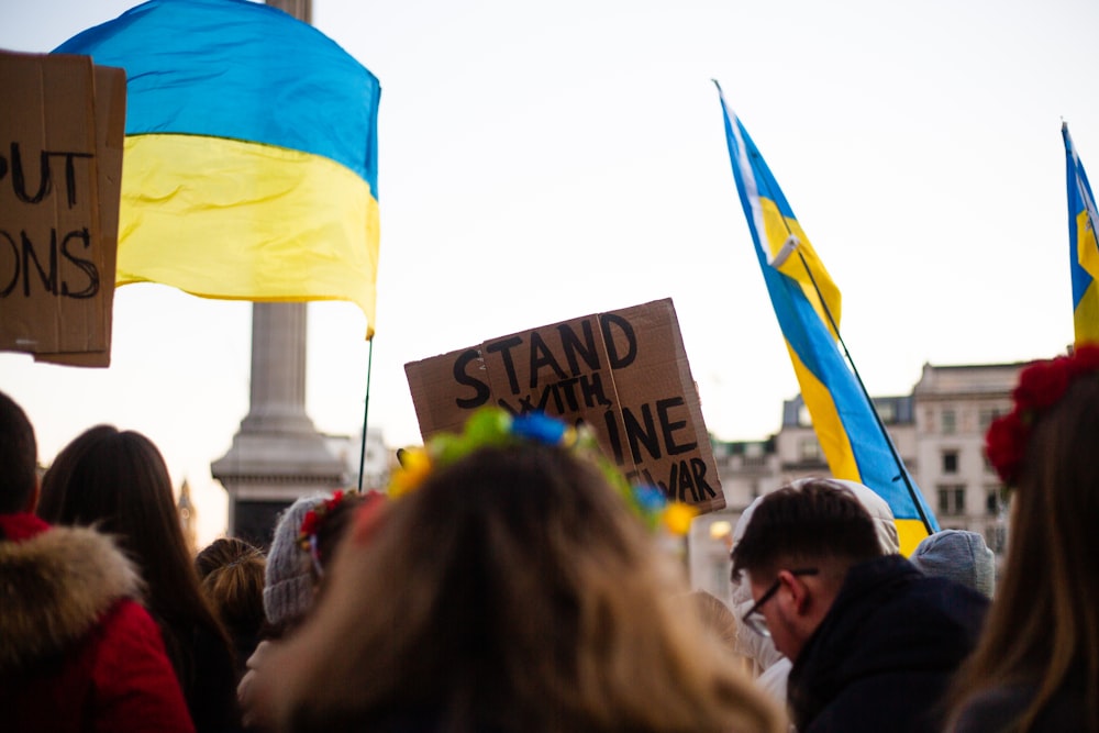 a crowd of people holding signs and flags