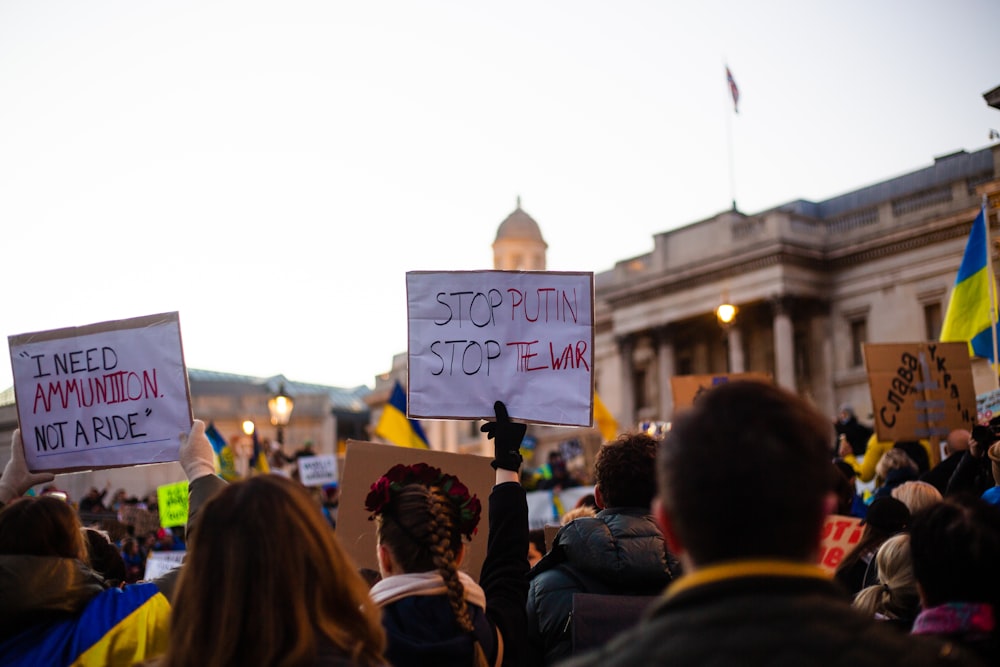 a group of people holding signs in front of a building