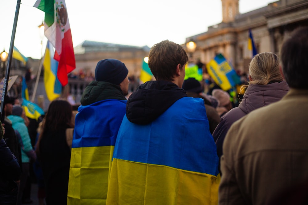 a group of people walking down a street holding flags