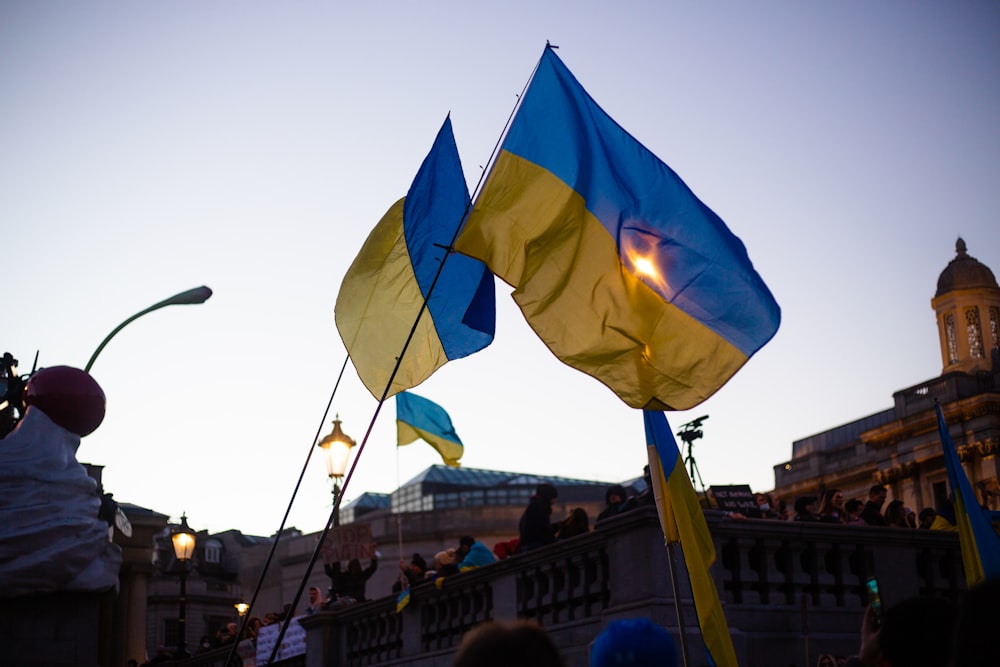 a group of people holding flags in front of a building