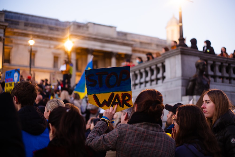 a crowd of people holding signs in front of a building