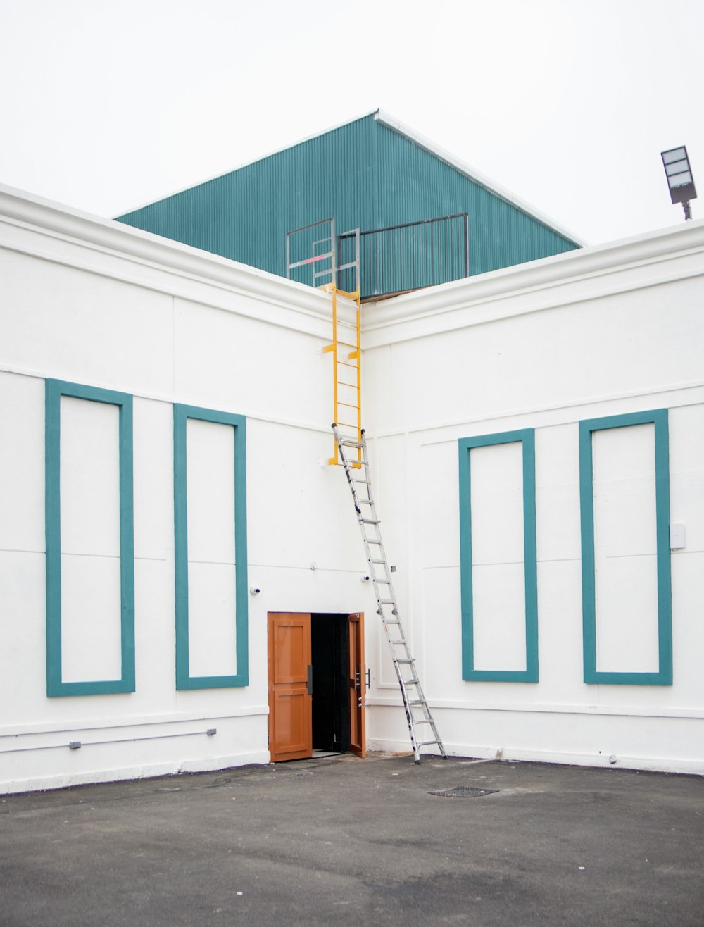 a building with a ladder going up to a door