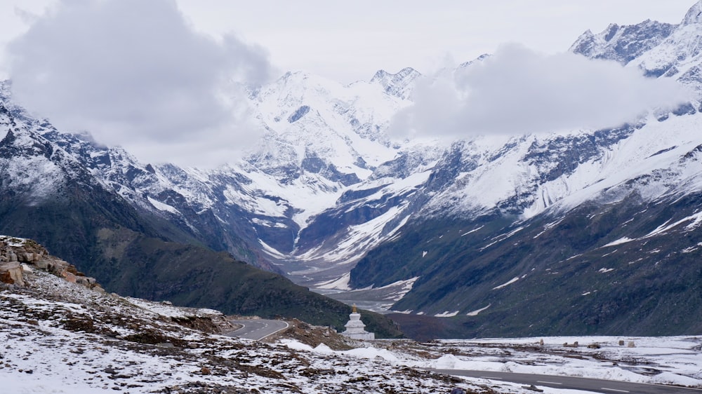 a snow covered mountain range with a road in the foreground