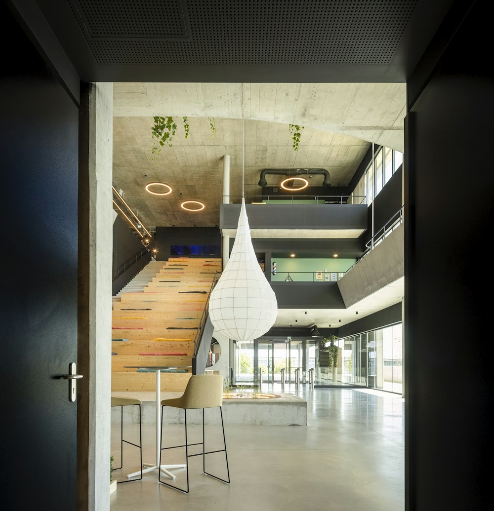 a room with a staircase and a table and chairs