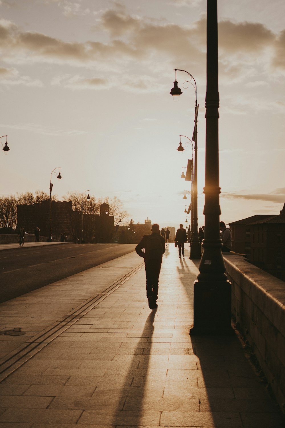 a person walking down a sidewalk next to a street light