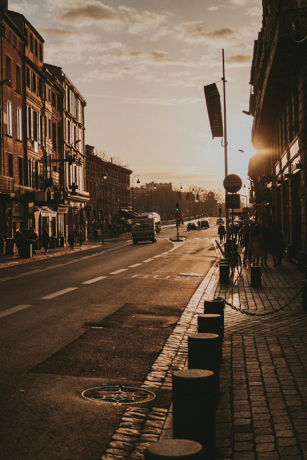 the sun is setting on a city street