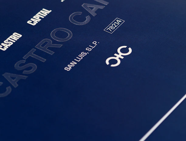 A close-up of a sleek dark blue cover design featuring text in white and light gray, including 'CASTRO CAPITAL .COM', 'SAN LUIS, S.L.P.', and a number '78214'. The design includes a stylized logo with interlocking letters.