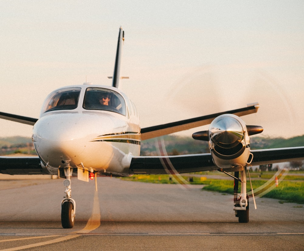 a small white airplane sitting on top of an airport runway