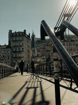 a group of people walking across a bridge