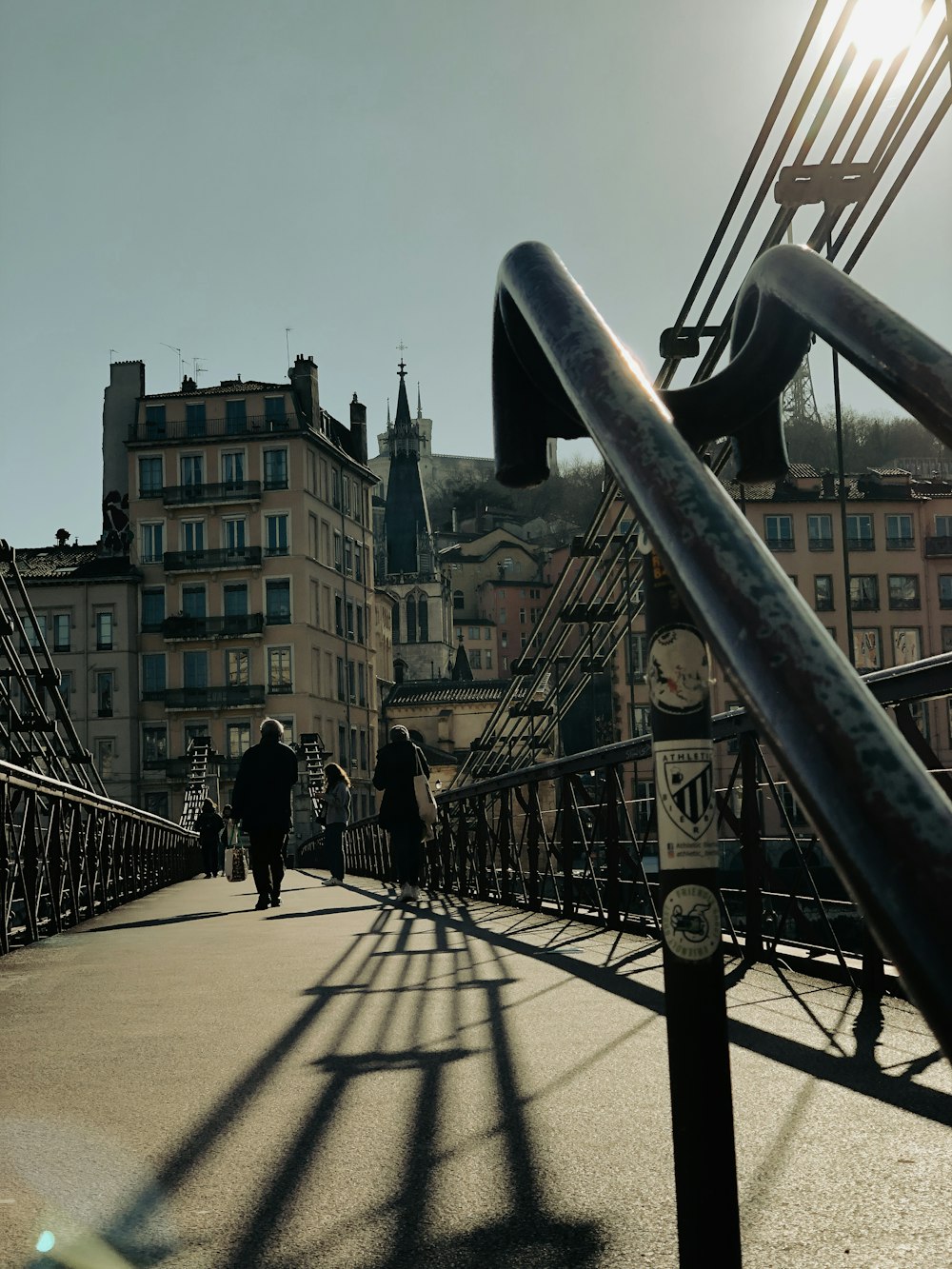 a group of people walking across a bridge