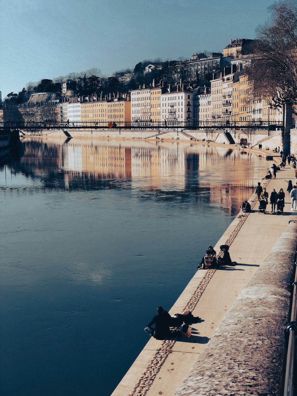 a group of people sitting on the side of a river