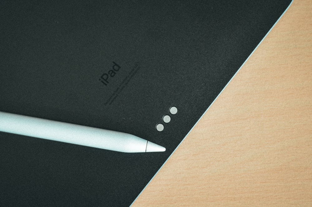 a pen sitting on top of a black notebook