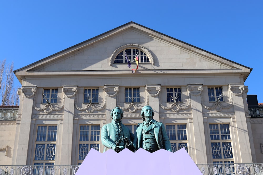 a large building with two statues in front of it