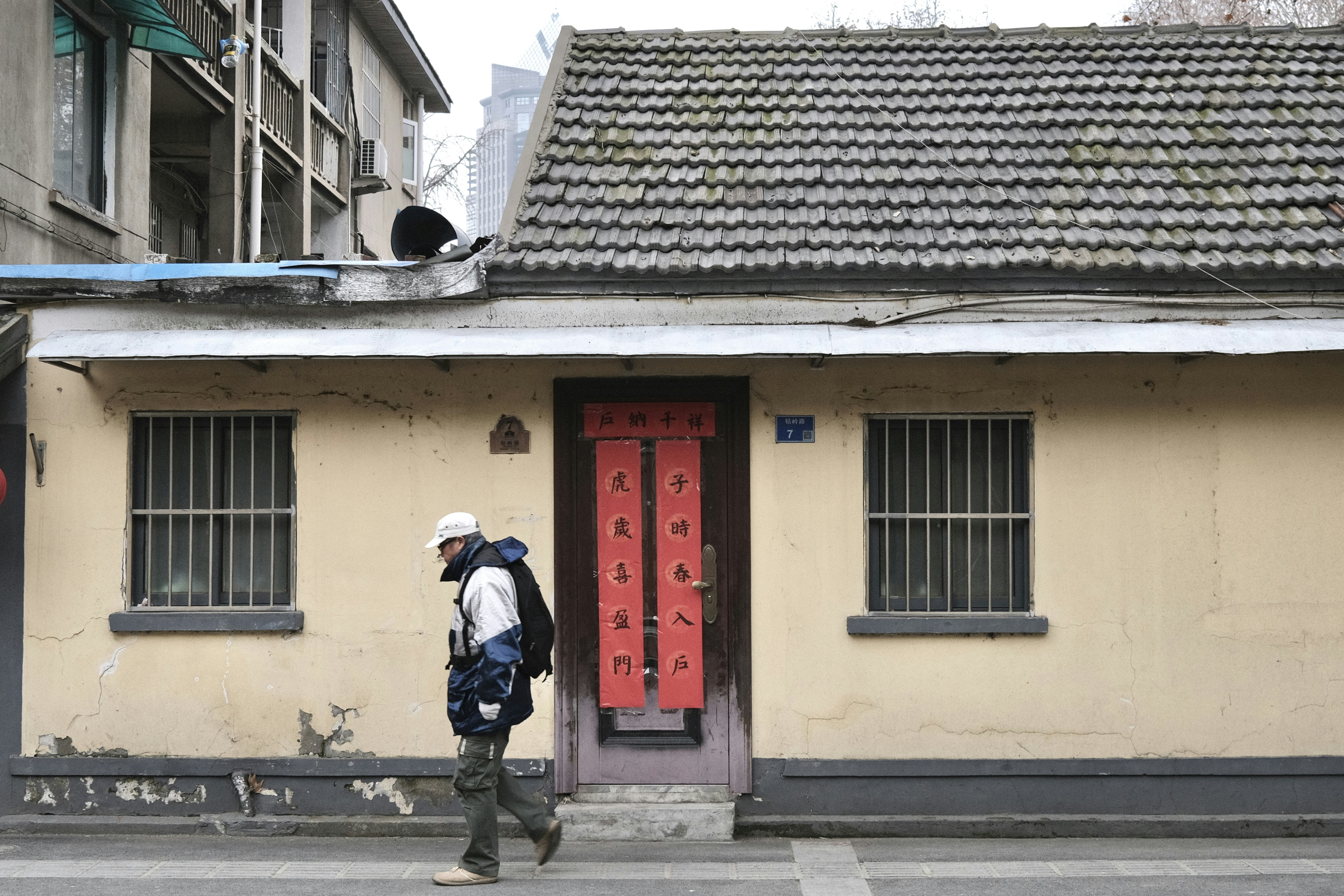 a man walking down a street past a building