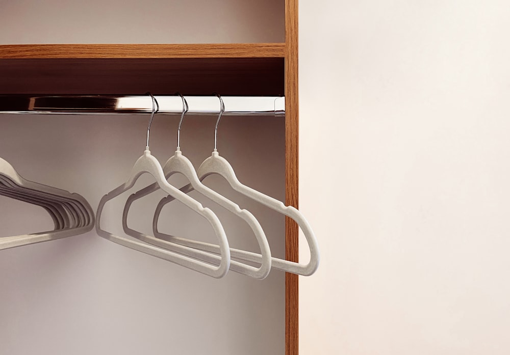 a closet with three hangers and a toothbrush
