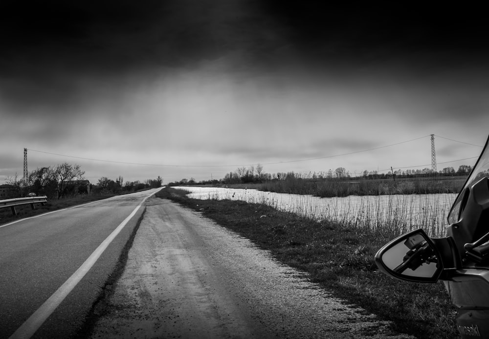 a black and white photo of a road and a car