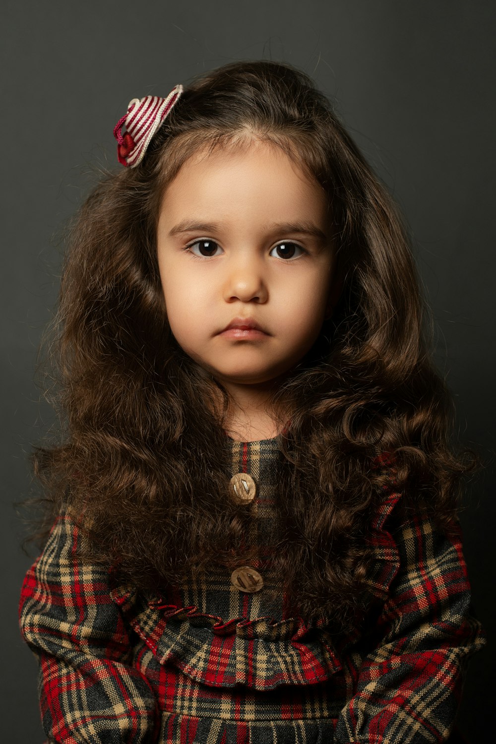 a little girl with long hair and a bow in her hair