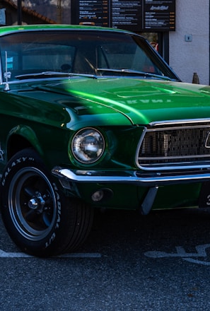 a green mustang parked in a parking lot