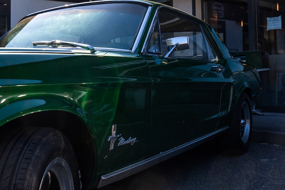 a green car is parked in front of a building