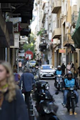 A busy city street with a motoveloce motorcycle taxi weaving smoothly through traffic.
