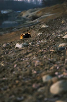 A rugged 4WD FPV truck climbing over rocky terrain with dust flying.