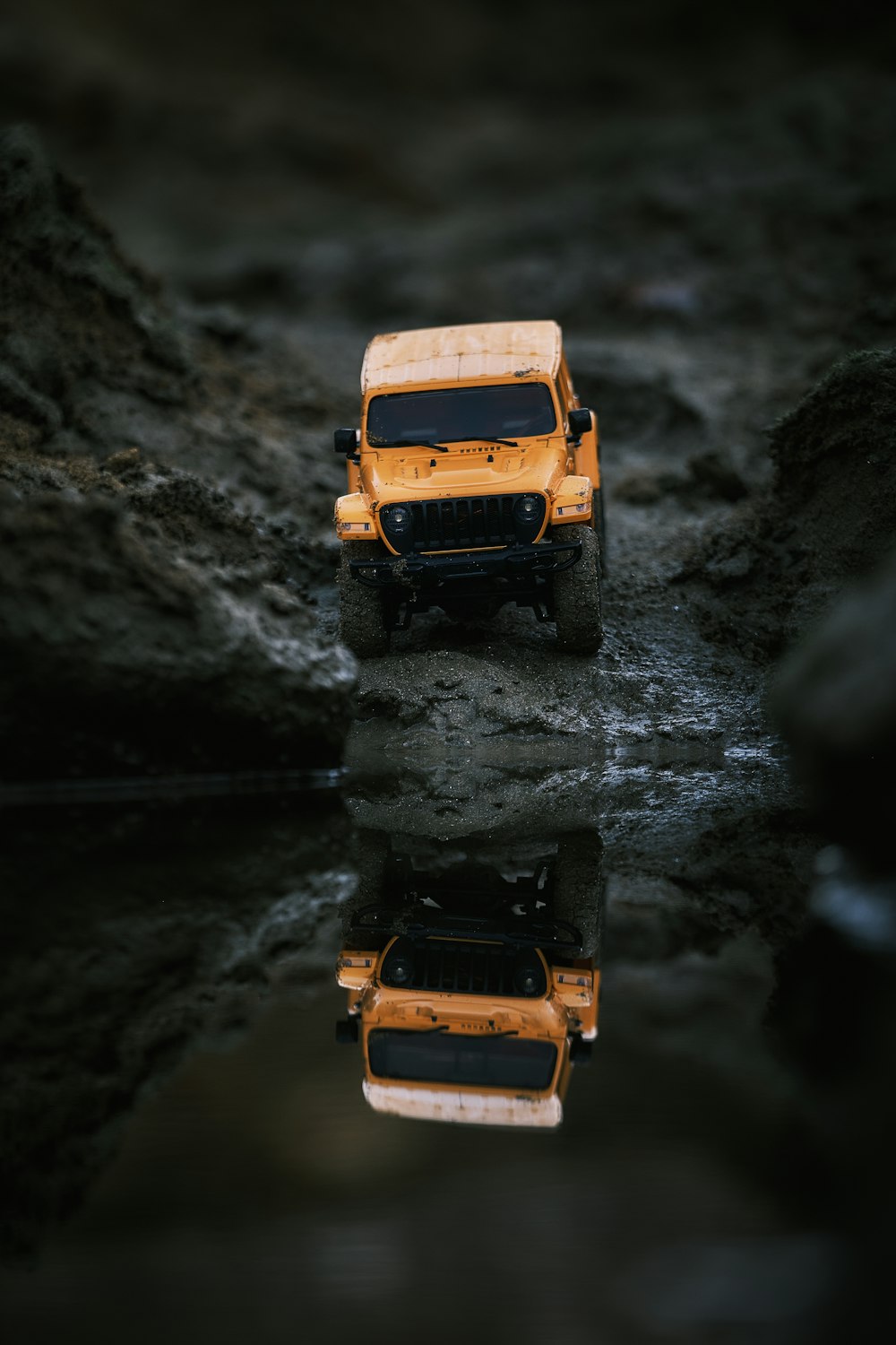 a yellow jeep is parked in the mud